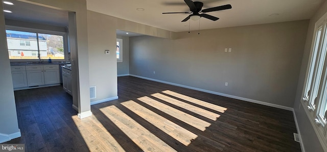 unfurnished room with sink, ceiling fan, and dark wood-type flooring