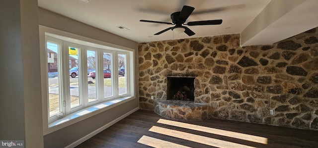 unfurnished living room featuring ceiling fan, dark wood-type flooring, and a fireplace