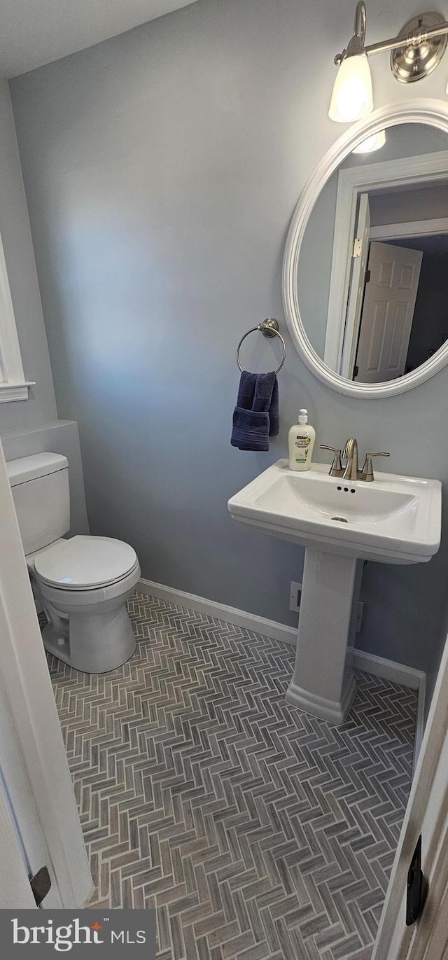 bathroom with toilet and tile patterned flooring