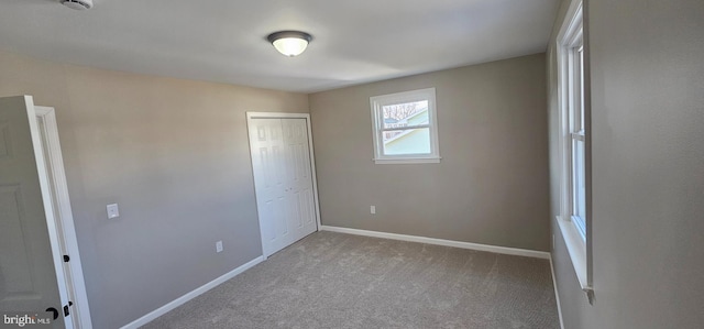 unfurnished bedroom with a closet and light carpet