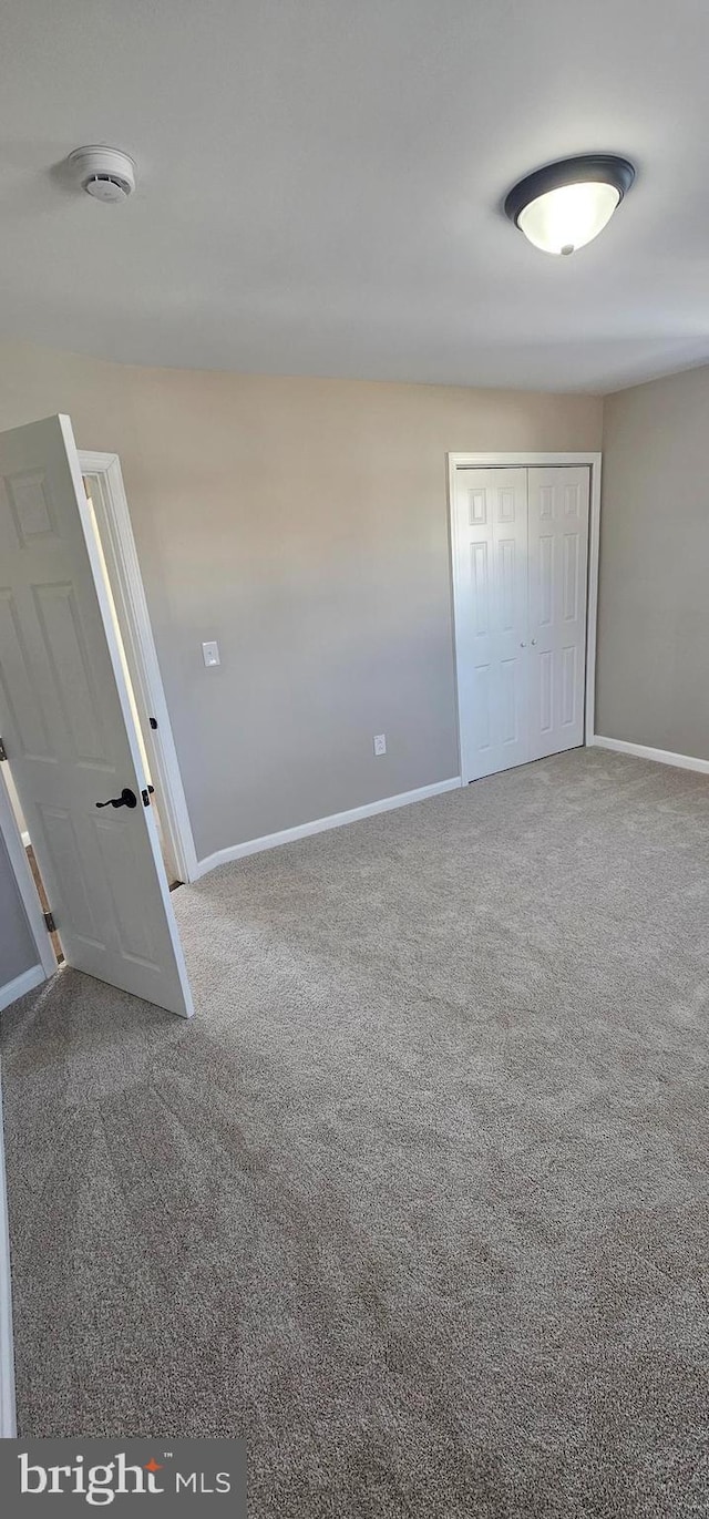 unfurnished bedroom featuring a closet and carpet floors