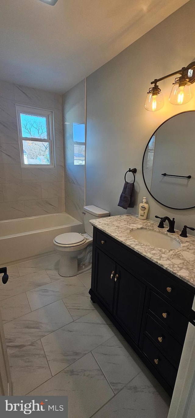 full bathroom with toilet, vanity, and tiled shower / bath