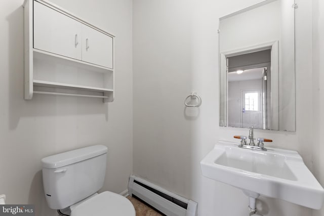 bathroom with sink, toilet, and a baseboard heating unit