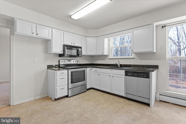 kitchen with stainless steel appliances, a baseboard heating unit, white cabinets, and sink