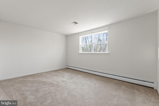 carpeted spare room with a baseboard heating unit