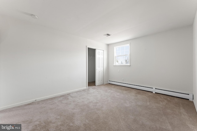 carpeted spare room featuring baseboard heating