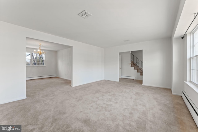 spare room with a notable chandelier, light colored carpet, and a baseboard radiator