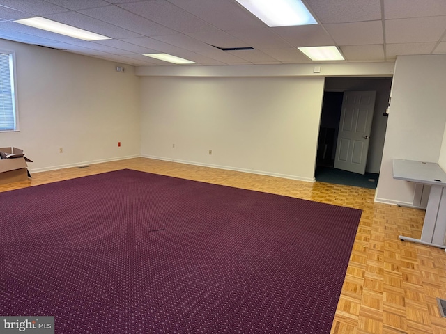 spare room with a paneled ceiling and light parquet flooring