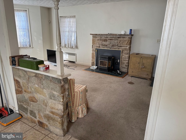 living room featuring carpet floors, a wood stove, and radiator