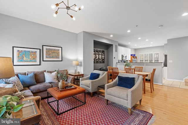 living room with an inviting chandelier and light hardwood / wood-style floors