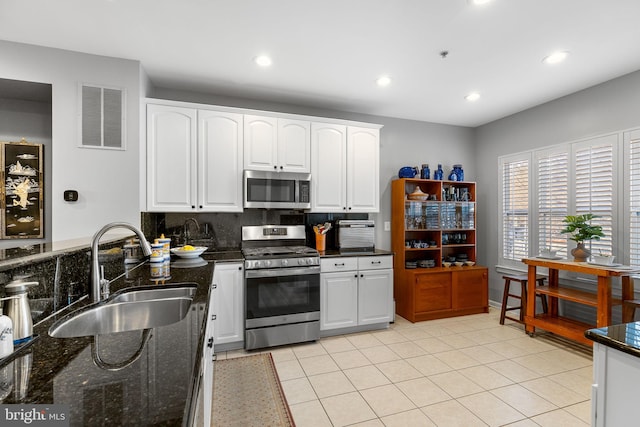 kitchen featuring sink, stainless steel appliances, white cabinets, and decorative backsplash