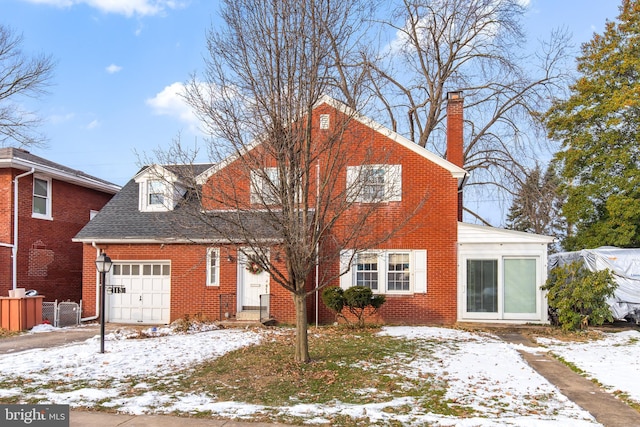 snow covered property featuring a garage