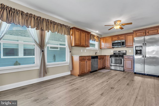 kitchen with plenty of natural light, ceiling fan, stainless steel appliances, and light hardwood / wood-style flooring