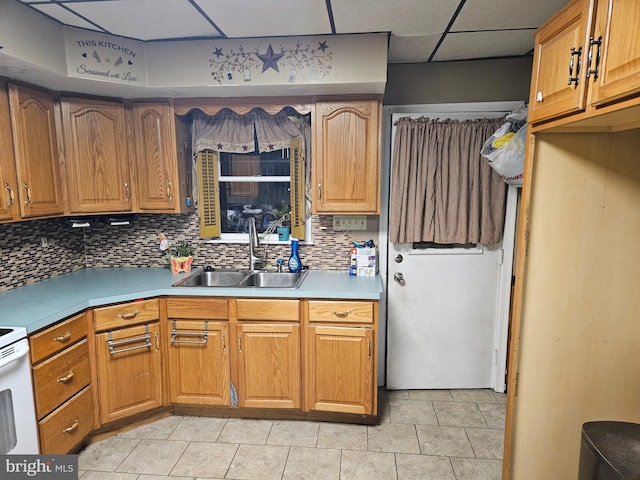 kitchen featuring sink, backsplash, a paneled ceiling, and light tile patterned floors