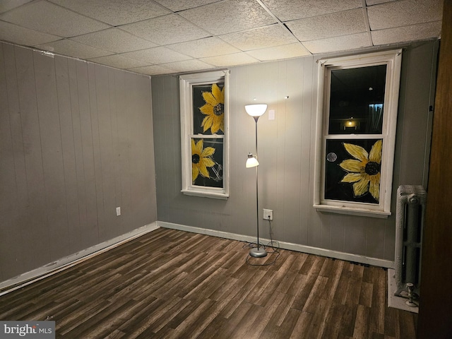 spare room featuring radiator and dark hardwood / wood-style flooring