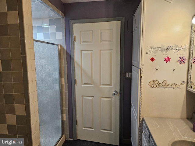 bathroom with vanity and a shower with door