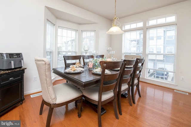 dining area featuring plenty of natural light and light hardwood / wood-style flooring