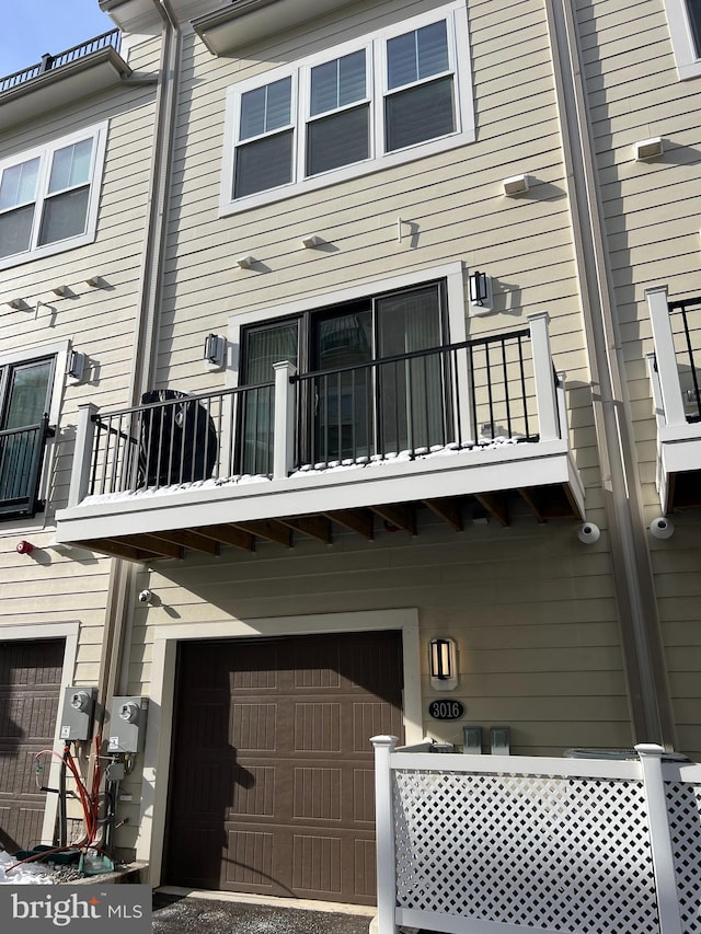 rear view of house with a balcony and a garage