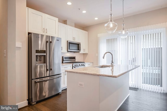 kitchen with sink, stainless steel appliances, white cabinetry, and an island with sink