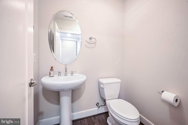 bathroom with toilet and wood-type flooring