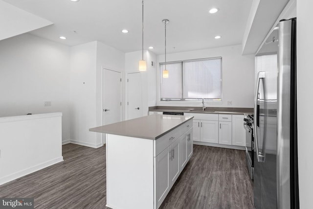 kitchen with a center island, white cabinets, sink, hanging light fixtures, and stainless steel appliances