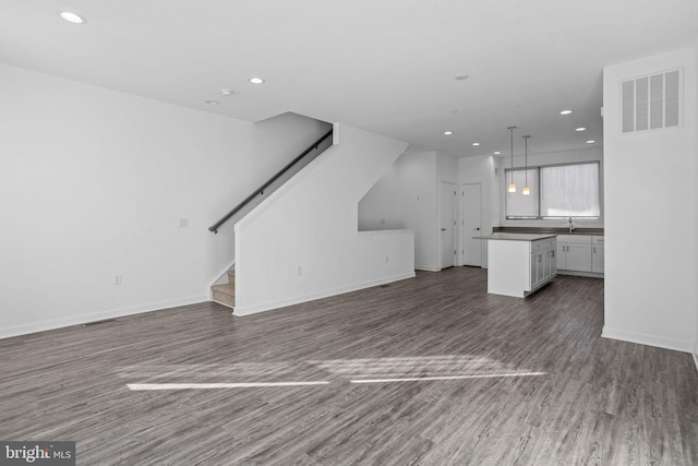 unfurnished living room with dark hardwood / wood-style flooring and sink