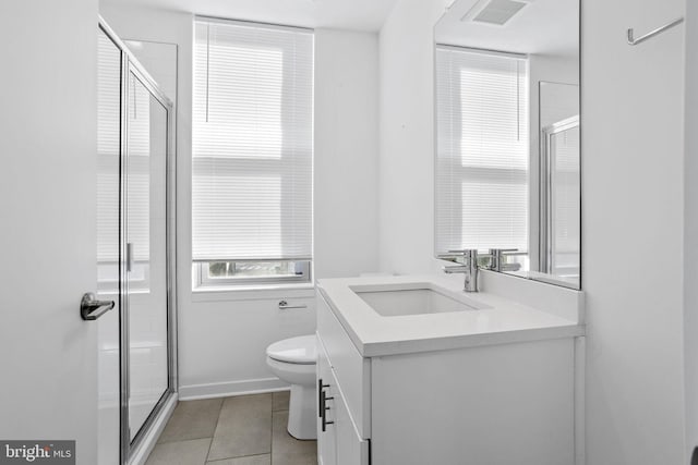 bathroom featuring tile patterned floors, vanity, toilet, and walk in shower