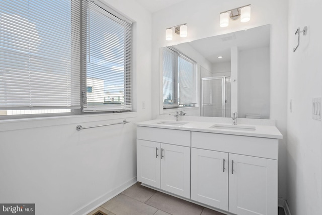 bathroom with tile patterned flooring, vanity, and a shower with door