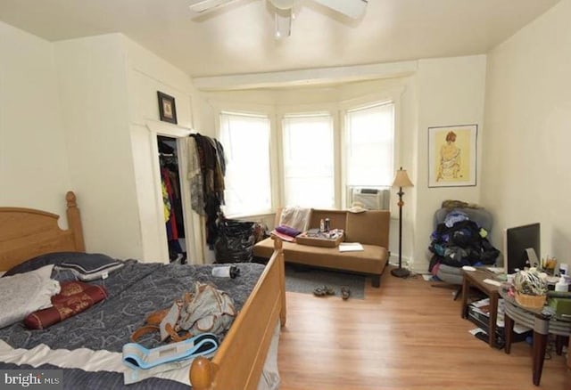 bedroom featuring light wood-type flooring, ceiling fan, and cooling unit