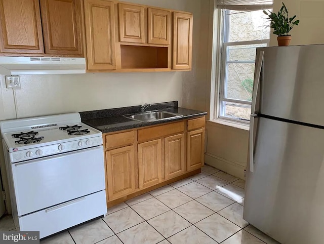 kitchen featuring stainless steel fridge, white range, light tile patterned floors, and sink