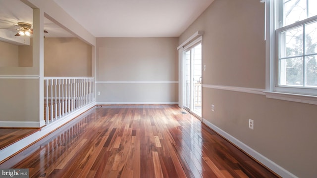 unfurnished room featuring baseboards, a ceiling fan, and hardwood / wood-style flooring