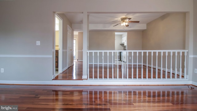 hallway featuring baseboards and wood finished floors