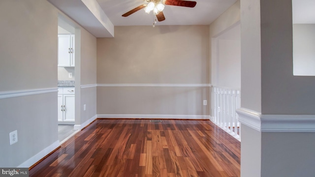 empty room with wood finished floors, baseboards, and ceiling fan