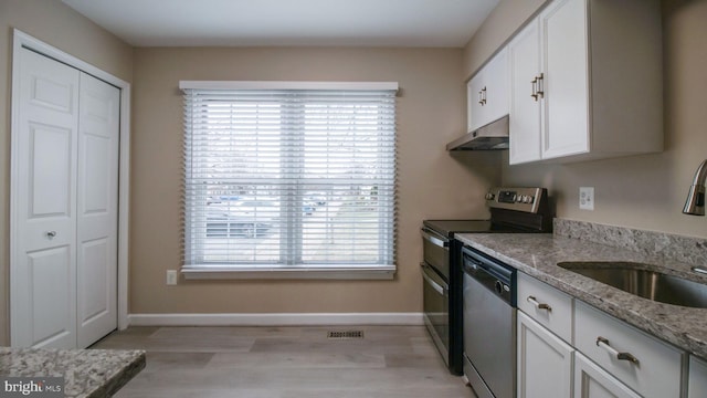 kitchen with under cabinet range hood, stainless steel appliances, white cabinets, and a sink