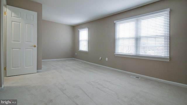 unfurnished room featuring baseboards, visible vents, and carpet floors