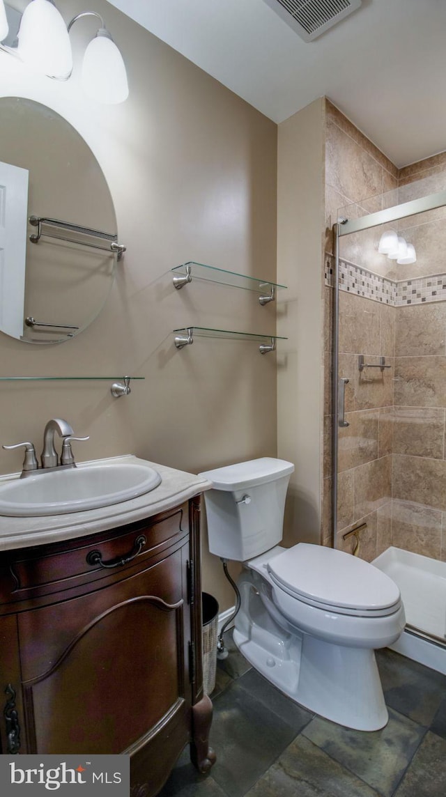 bathroom with visible vents, a stall shower, toilet, and vanity