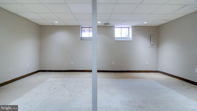 below grade area with a drop ceiling, recessed lighting, and baseboards