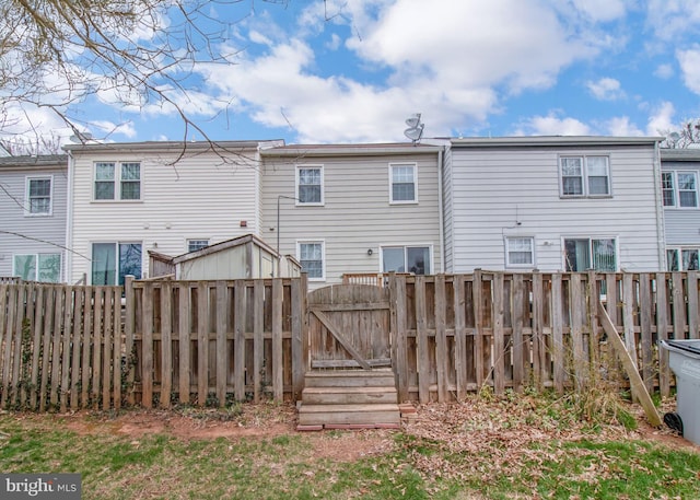 back of property with a gate and a fenced backyard