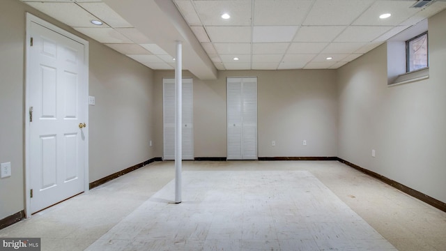 finished basement featuring recessed lighting, a paneled ceiling, and baseboards