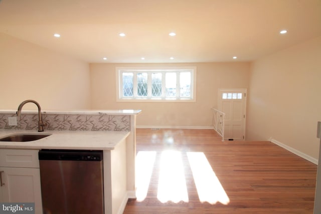 kitchen featuring sink, white cabinetry, dishwasher, and light wood-type flooring