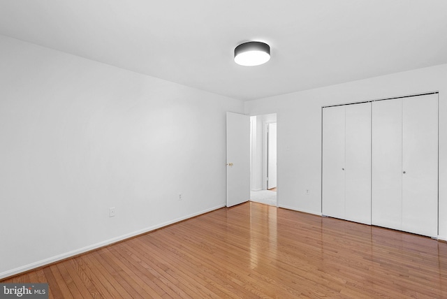 unfurnished bedroom with light hardwood / wood-style floors and a closet