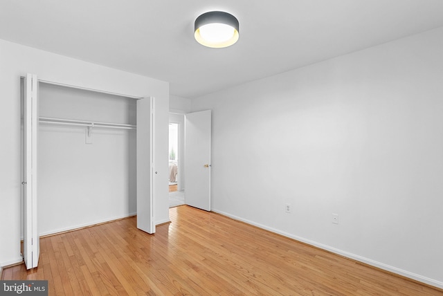 unfurnished bedroom featuring light hardwood / wood-style floors and a closet