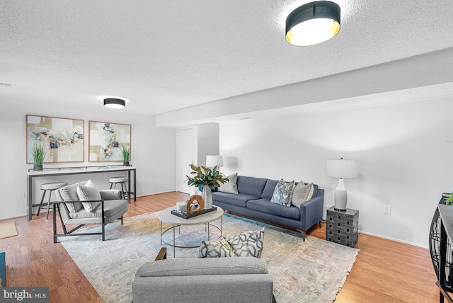 living room featuring light hardwood / wood-style flooring and a textured ceiling