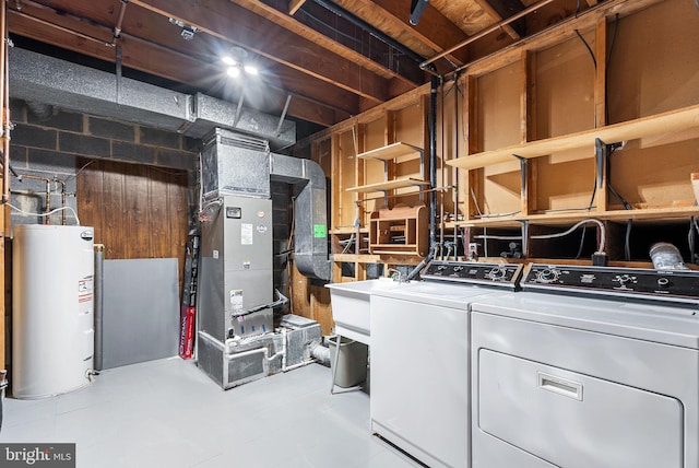 clothes washing area with washer and clothes dryer, electric water heater, and heating unit