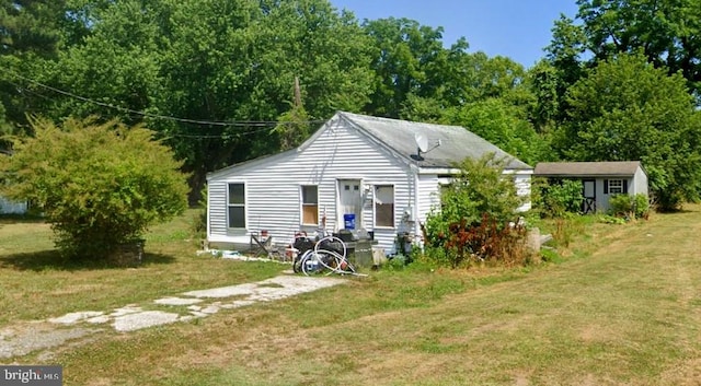 view of front facade with a storage shed and a front lawn