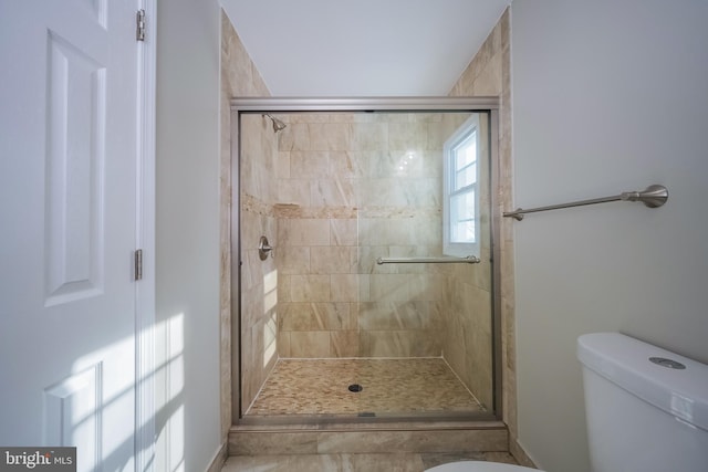 bathroom featuring an enclosed shower and toilet