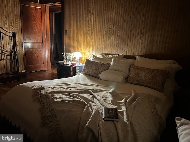 bedroom featuring wooden walls