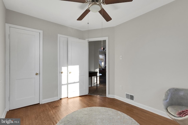 sitting room with ceiling fan and hardwood / wood-style floors