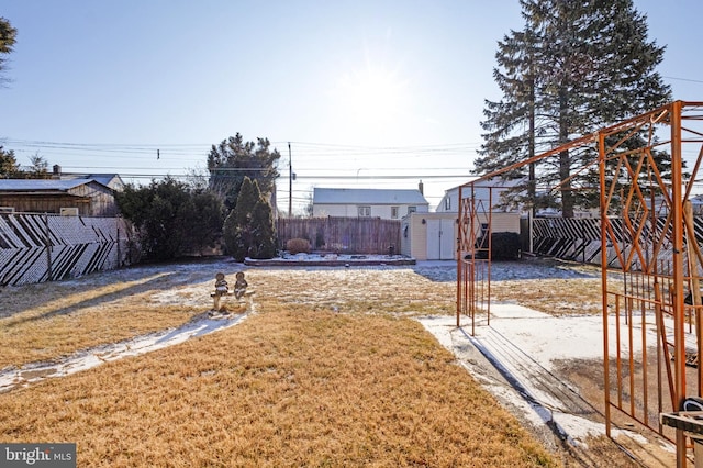 view of yard with an outdoor structure, a fenced backyard, and a shed