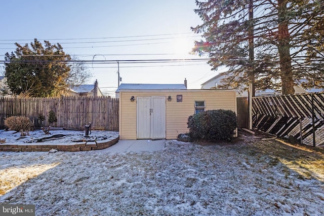 snowy yard with an outbuilding and a fenced backyard